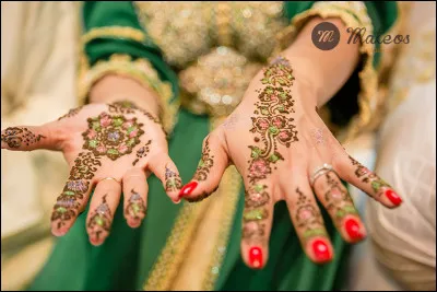 C'est le moment phare de la cérémonie très importante, qui apportera selon la coutume, la bénédiction dite "baraka" à l'union des époux, une poudre mélangée avec du lait ou de l'eau à la fleur d'oranger, qui forme une pâte posée sur un plateau entourée de 2 bougies, va servir à décorer les mains de la mariée :