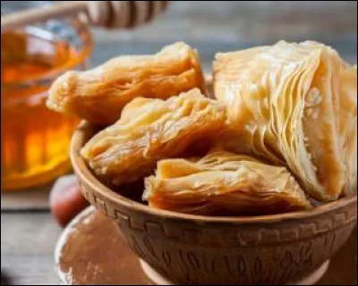 Originaire de l'Empire ottoman, riche et sucré, fait de couches de filo fourrées de noix hachées et sucrées et maintenues ensemble avec du sirop, du glaçage ou du miel, je suis...