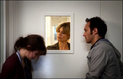 L'image montre Marina Foïs (la femme blonde derrière la vitre) dans...