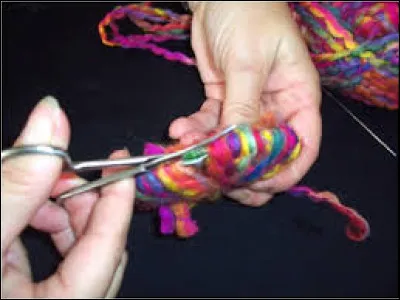 On arrive à l'étape délicate qui demande un peu de _______ .
Il faut maintenir la laine au centre et découper la laine à l'extérieur entre les disques.