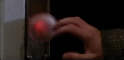 Quelle lettre se retrouve sur la main du cambrioleur Harry après qu'il se soit brûlé sur la poignée de porte ?