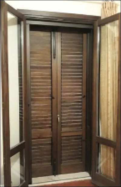 Quelle est cette porte composée de deux vantaux formés de lames inclinées qui arrêtent le soleil en laissant passer l'air ?