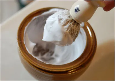 Quel est le nom de cette brosse utilisée pour appliquer du savon à barbe sur un visage avant de le raser ?