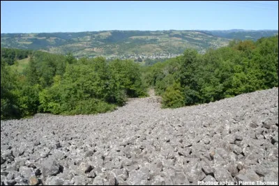 La ''coulée de lave de Roquelaure'' descend vers Saint-Côme-d'Olt et le Lot. Il s'agit en réalité d'un éboulis de roches basaltiques, libérées par l'érosion. Où se trouve-t-elle ?