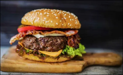 Quel est ce mets originaire d'Hambourg, un sandwich à base de pain, garni de viande hachée, de crudités, de salade, de concombre, de tomates et de sauce ?