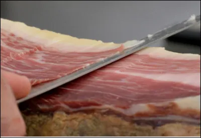 Quel est ce met, un jambon cru de porc ibérique de race pure, élevé en plein air et nourri essentiellement de glands, affiné entre 8 et 36 mois ?