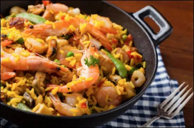 Quel est ce plat à base de riz safrané et d'ingrédients variés comme des fruits de mer, du poulet, de la charcuterie et des légumes ?