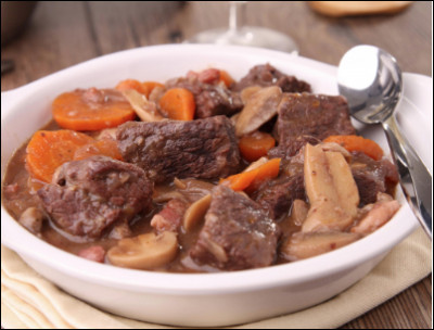 Quelle est cette recette à base de cubes de viande de boeuf, de carottes, de lardons, de champignons, de farine, d'huile, d'épices et de vin rouge ?