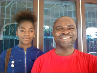 Regardez l'image : la personne derrière l'homme en tricot rouge est...