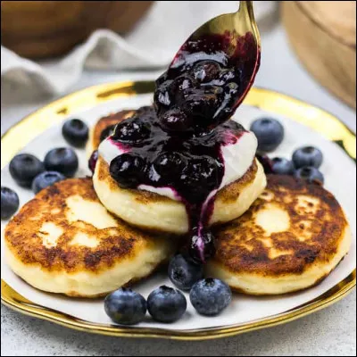 C'est une sorte de beignet russe à base de fromage frais qu'on agrémente de confiture, crème fraîche, miel.