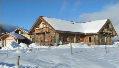 Maison en rondins de bois brut empilés, ajustés et entrecroisés aux angles.