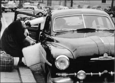 Pas simple de monter avec sa coiffe en pays Bigouden. Quelle est cette auto des années 50 ?