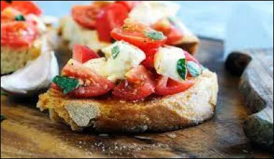 La bruschetta est une tartine de pain grillé, frotté à l'ail et garni de tomates séchées, feuilles de basilic et couvert d'un peu d'huile d'olive.