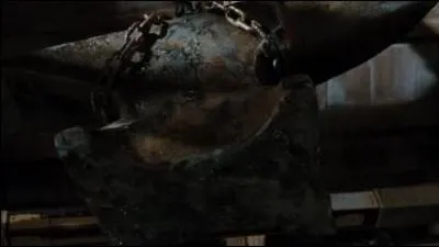 Avec quoi coupe-t-elle la corde supportant l'enclume dans sa remise ?