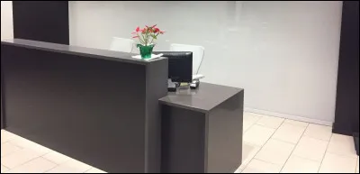 Une personne vous accueille dans ce lieu qui se situe à l'entrée. Quelle est la couleur du mobilier ?