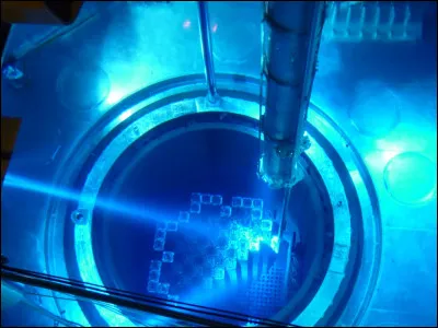 À quel effet doit-on la couleur bleue de l'eau, dans la piscine du bâtiment combustible ?