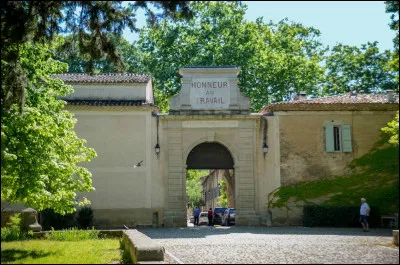 Quel est cet édifice, situé près de Clermont l'Hérault, qui affiche sur son fronton "honneur au travail" ?