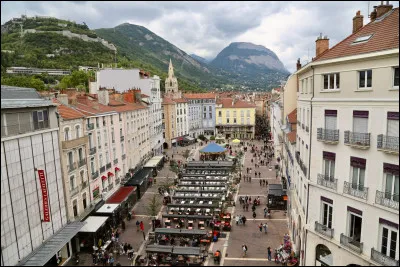 La "place Grenette", piétonne, couverte de terrasses, est au coeur de cette ville. Vous devriez pouvoir apercevoir la montagne. Dans quelle ville êtes-vous ?