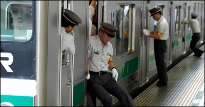 Les Japonais en uniformes ont pour métier de pousser les civils pour les faire rentrer dans le train. Comment les appelle-t-on ?