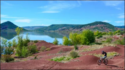 Ses berges sont constituées de roche qui ont une couleur rouge vif. Comment se nomme ce lac artificiel situé dans l'Hérault ?