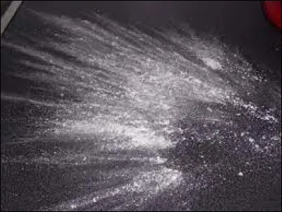 Action de saupoudrer de la farine sur un poste de travail.