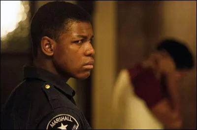 Dans quel film John Boyega interprète-t-il un homme noir qui essaye d'en protéger d'autres contre des policiers racistes ?