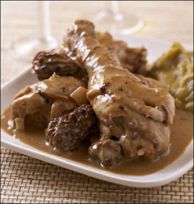 Quelle est la couleur du vin dans lequel est préparé le coq accompagné de morilles, selon une célèbre recette traditionnelle du Jura ?