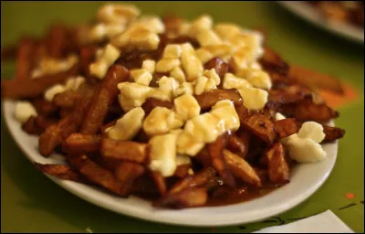 Quelle commune a pour spécialité la poutine, un plat à base de frites, de fromage en grains et de sauce brune ?