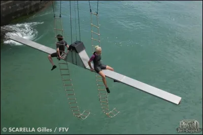 Quel est le nom de l'épreuve aérienne dans laquelle 2 personnes sont placées à l'extrémité d'une grande barre horizontale et doivent récupérer 2 codes au bout de cette barre horizontale ?