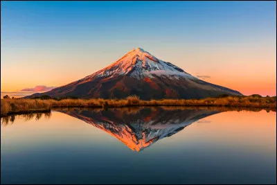 Nous sommes à l'autre bout de la planète, en Océanie, devant le mont Taranaki, aussi appelé mont Egmont. C'est un volcan culminant à 2 518 mètres. La vue est sublime depuis le lac Mangamahoe.