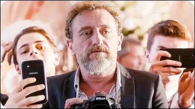 Quel objet, Guy le photographe, trimballe-t-il tout le temps avec lui ?