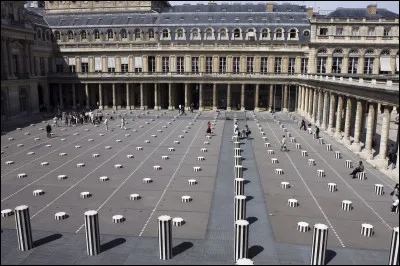Quel est l'artiste français, auteur de cette oeuvre d'art qui comporte 64 colonnes en marbre blanc avec des raies noires, située dans la cour du Palais-Royal à Paris ?