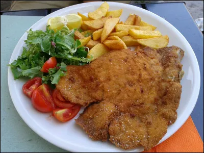 Quel est ce plat en E, typique de la cuisine italienne, une escalope panée de viande de veau cuite au beurre et accompagnée de citron et de légumes ?