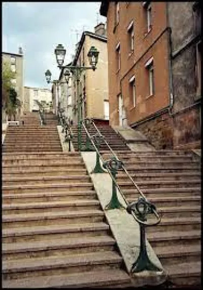 Dans quelle ville gravirez-vous la rue en escalier du Crêt de Roc ?