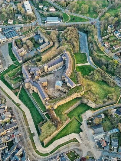 Quelle est cette ville du département des Ardennes où se trouve le plus grand château fort d'Europe, construit en 1424 ?