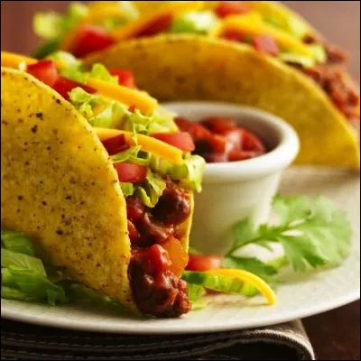 Quel plat de la cuisine mexicaine est une tortilla de maïs repliée sur elle-même et garnie ?