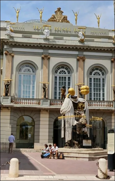 L'entrée doit se faire par cette place, sur laquelle on peut voir une belle statue surréaliste. À qui rend-elle hommage ?