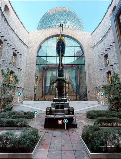 Le "Vestibule" n'est pas une pièce très intéressante, donc je me suis permis de passer directement au "Patio", une belle cour intérieure de style espagnol. Quelle est la marque de la voiture présente au centre de l'image ?