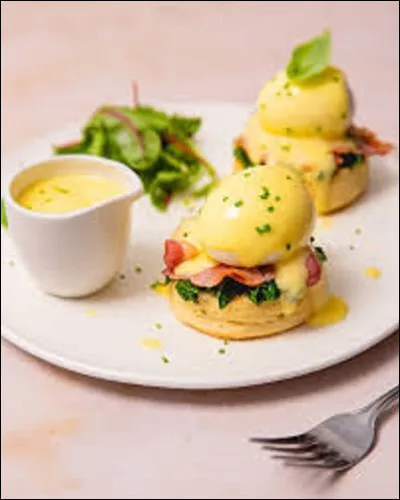 Les Œufs Bénédicte est une spécialité américaine. Plat à base d'œufs composée de moitié de muffin anglais grillée, recouverte d'une tranche de bacon frit, d'un œuf poché. Avec quelle sauce recouvre-t-on le tout ?