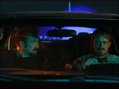 Un homme conduit un autre homme mystérieux qui le menace d'une arme, dans...