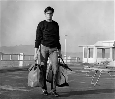 En 1956, pour quel motif, Alain Delon est-il exclu de la Marine nationale puis renvoyé en France ?