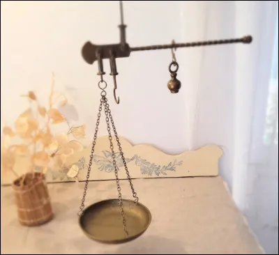 Quel est ce type de balance ancienne avec un fléau suspendu par une anse à 2 bras dont le plus court porte un plateau ou un crochet pour peser ?