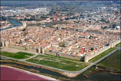 Quelle est cette ville de 8 000 habitants, située dans le sud du département, à proximité des étangs, célèbre pour ses remparts du XIIIe siècle ?