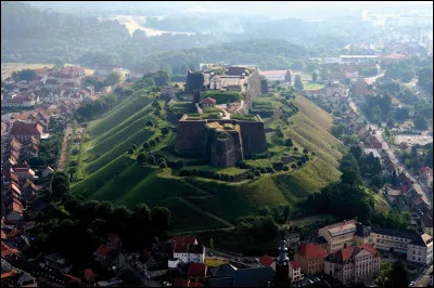 Quelle est cette ville de 5 000 habitants, située dans l'est du département, près de la frontière allemande, dominée par son imposante forteresse ?