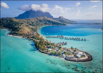 Nous sommes maintenant à la plage de Matira, en France, avec une belle vue sur la montagne. Par contre, dans quel région d'outre-mer de la France, sommes-nous ?
