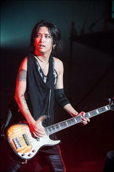 Avant de devenir bassiste, AKi se passionnait pour un autre instrument. Lequel ?