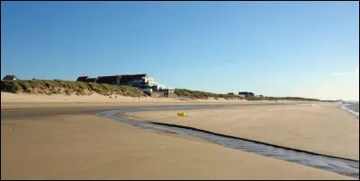 Quelle est cette commune littorale, située à l'extrémité nord du département, connue pour sa plage et ses dunes, célèbre à travers le roman de Robert Merle ?