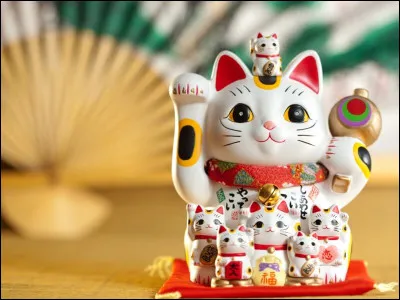 Que symbolise la patte levée du maneki-neko ?