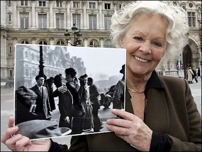 Cette dame nous présente une photo que vous reconnaîtrez. Quel photographe célèbre a immortalisé ce baiser mythique représentant l'amour à Paris au printemps, en 1950 ?