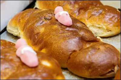 Traditionnellement, que représente la figurine sur le cougnou belge ?